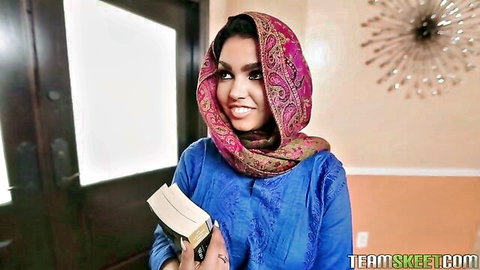 Ada Sanchez in pink hijab and blue dress, smiling seductively with book