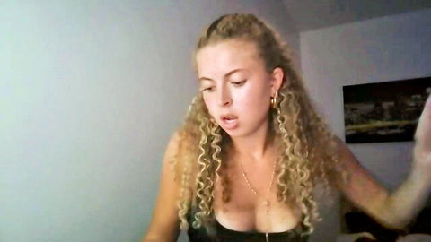 Sara Baller curly blonde cam girl teasing cleavage in black top