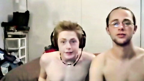 Two shirtless young men with headsets in close-up amateur webcam pose