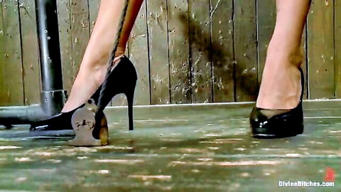 Mistress in black high heels dominates by crushing submissive mask