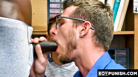 Bearded white guy in glasses deepthroats massive BBC while another watches in library