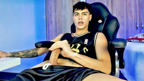 Tattooed hunk in Celtics jersey pulls down shorts to grip thick erect cock on webcam