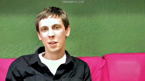 Derick Jett in casual black shirt on pink couch