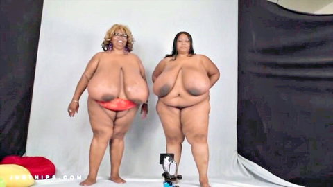 Two busty black BBW women posing nude with huge breasts in red bottoms