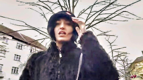 Goth brunette in fur coat and hat poses seductively outdoors with open mouth
