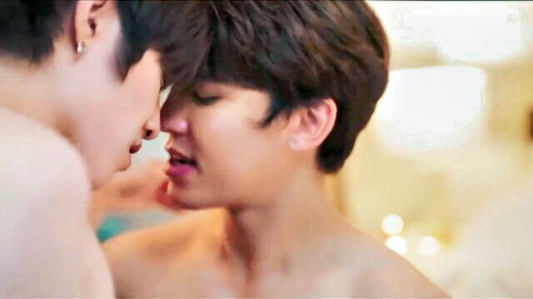 Two shirtless Asian hunks passionately kissing close-up with intense eye contact