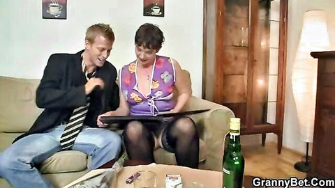 Short-haired mature woman in stockings teases lover with cleavage