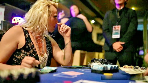 Blonde woman in black dress at poker table, seductive pose after losing bet