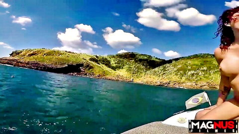 Topless redhead Brazilian woman on boat with scenic ocean view