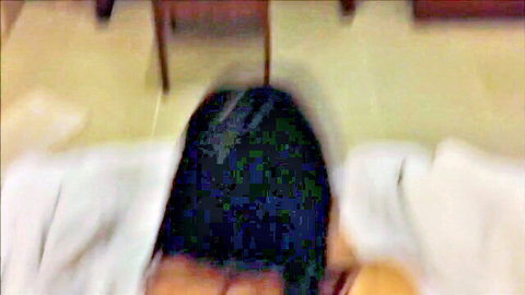 Brunette with wet black hair lying face down nude on bed viewed from behind