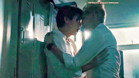 Two slim men in white shirts sharing an intimate embrace and kiss in boys love scene