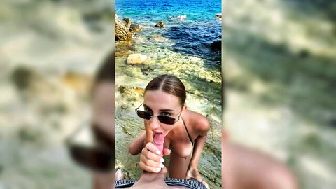 Busty brunette giving stranger blowjob and handjob on sunny beach