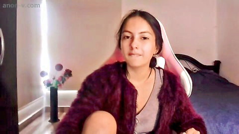 Smiling hijabi woman in fuzzy jacket and bunny ears, seductive webcam tease