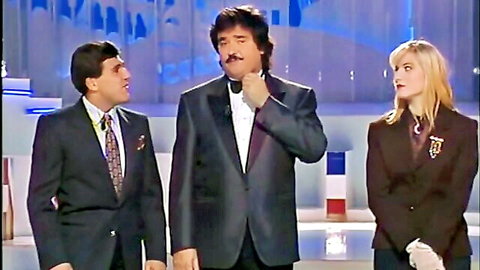 Vintage Colpo Grosso erotic TV show hosts: blonde woman in dress with two suited men on stage