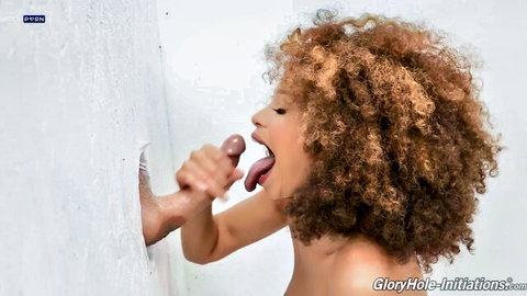Curly-haired ebony babe licks throbbing cock through gloryhole wall
