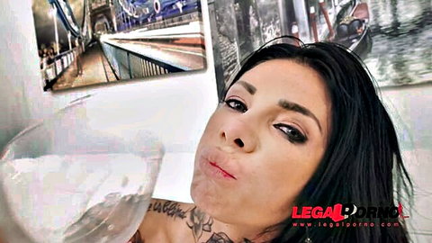 Tattooed brunette with glossy pouting lips and heavy makeup in sexy closeup selfie