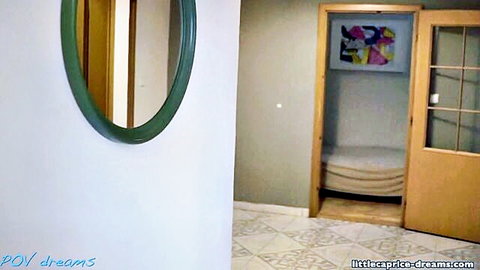 Empty cozy bedroom interior with green oval mirror and open door at Little Caprice Dreams