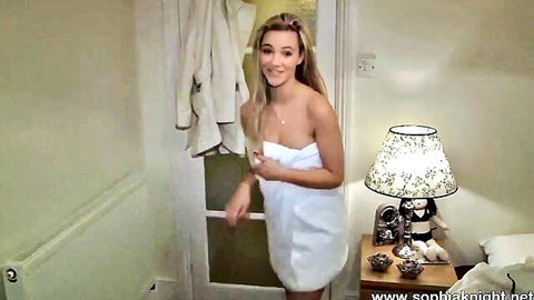 Skinny blonde teen in tiny white towel teasing with smile and cleavage in bedroom