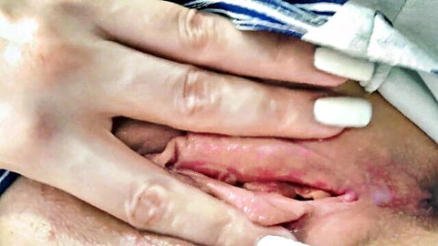 Close-up of woman spreading pussy while masturbating solo