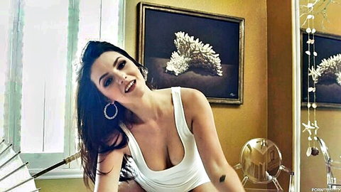 Brunette cutie in low-cut white tank top cleavage pose with Ryan Madison