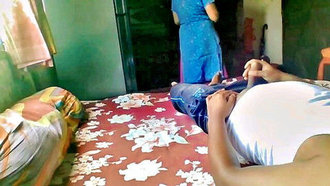 Pregnant Indian woman lies on bed with top lifted exposing huge bare belly and pants pulled down to thighs