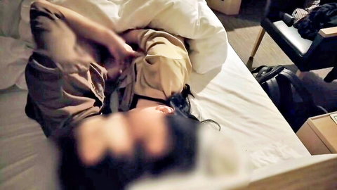 Amateur Asian woman with black hair sucking blurred man's cock on hotel bed under sheets