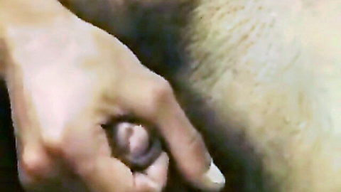 Close-up of hand stimulating exposed vulva with pubic hair in explicit adult scene