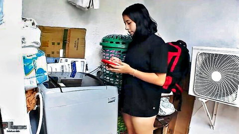 Sexy Asian amateur in tiny black shorts holding phone in laundry room
