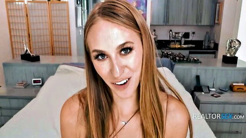 Busty blonde realtor Angel Youngs smiling seductively on bed