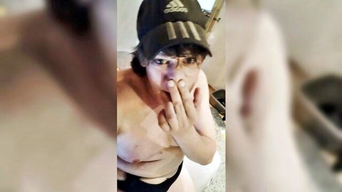 Shirtless Asian guy in Adidas cap and black speedo posing playfully