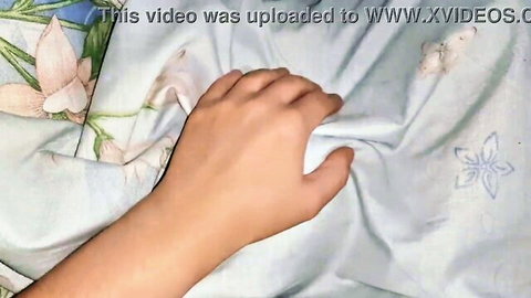 Hand gripping floral blanket in steamy lesbian threesome scene