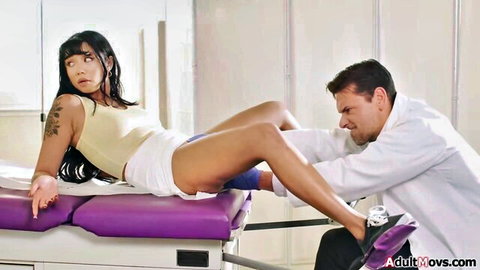 Petite Asian teen spreads legs in shorts as doctor grips her thigh on exam table