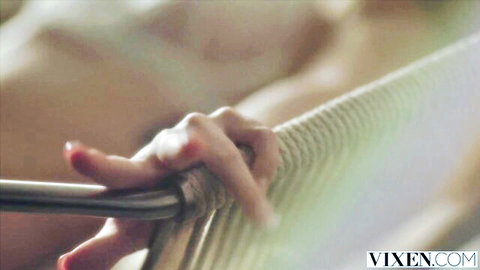 Sensual babe's red-nailed hand gripping thick metal pole teasingly in erotic closeup