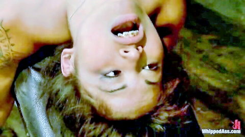 Upside-down Asian slave screams mouth wide open showing gold grill in femdom whipping torment