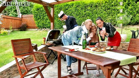 Sexy blondes and brunette pose for selfie with chef at outdoor BBQ party