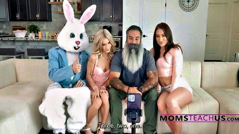 Easter bunny gropes lingerie-clad blonde's big tits while posing with bearded daddy and brunette babe on couch