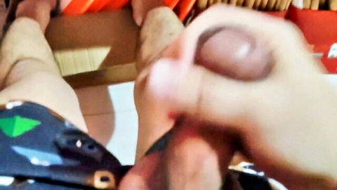 Filipino teen pulls aside black shorts to grip and stroke thick brown cock