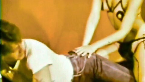 Vintage tease: woman in black lingerie gropes man in jeans from behind