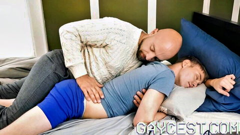 Bald stepdad spoons sleeping stepson in bed, hand on blue undies