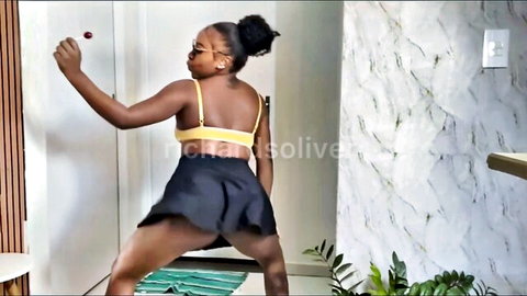 Ebony babe bends over in tiny black skirt exposing bare ass and pussy while dancing