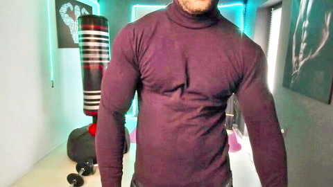 Bearded muscular man in tight maroon turtleneck posing seductively in gym