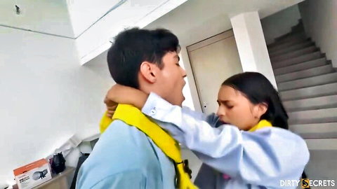 Young Asian teen brunette passionately kissing guy grabbing his neck collar intensely