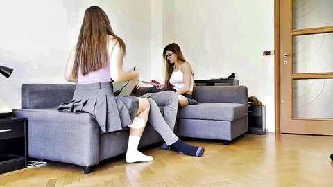 Two sexy amateur college girls in schoolgirl skirt and socks lounging on couch