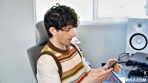 Curly-haired stepson in vest texts, awaiting classy stepmom's unique positions