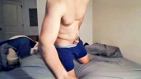 Muscular shirtless stud pulls down Calvin Klein boxers teasing pubic bush in bedroom webcam strip