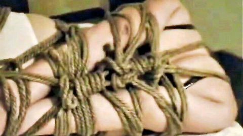 Submissive Asian in shibari bondage with ropes tightly bound around thighs and white panties