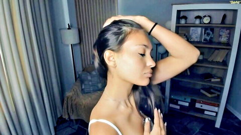 Young brunette teen in tight white tank top posing seductively on webcam solo