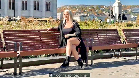 Lila Evance in sexy black dress on park bench, blonde pickup tease