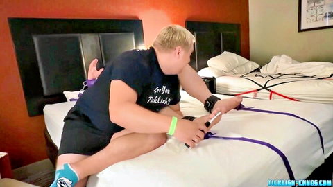 Chubby blonde hairy gay daddy ties purple BDSM ropes on bed holding phone for domination fuck