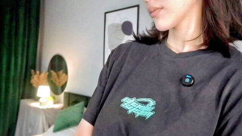 Seductive Asian webcam girl in graphic tee teases with sultry side glance and parted lips
